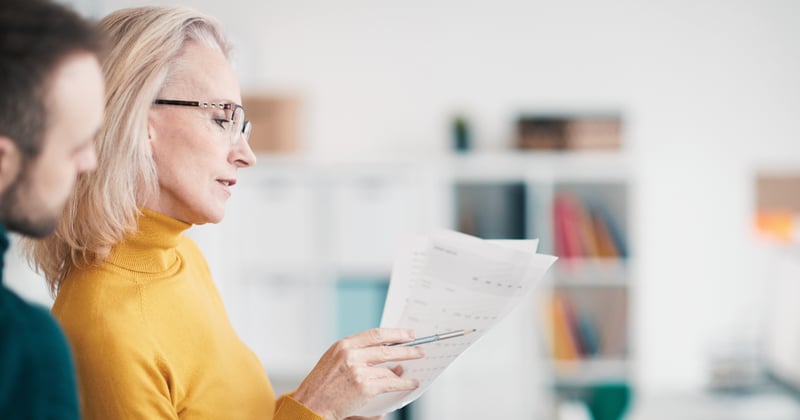 HR professionals looking at tracking sheets together.