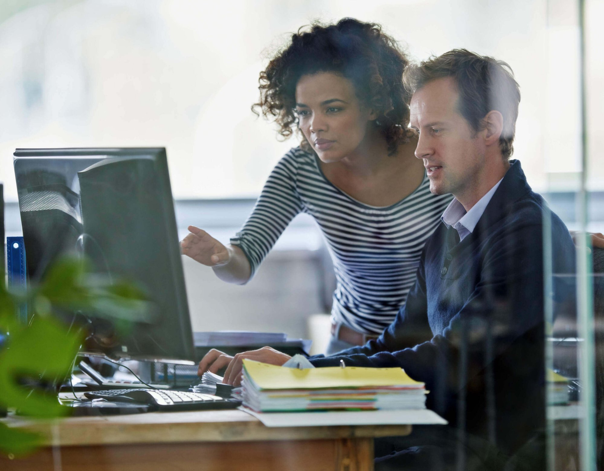 Professional benefits brokers looking at computer at office
